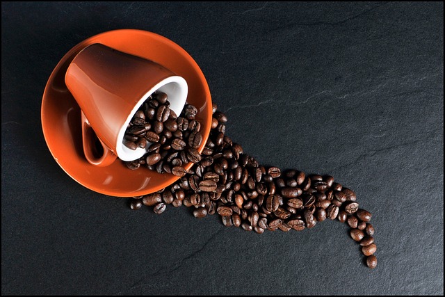 Coffee beans spilling out from a cup.